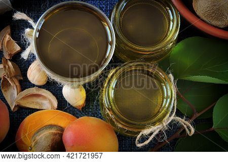 Jars Of Apricot Kernel Oil. Apricots, Leaves, Seeds.