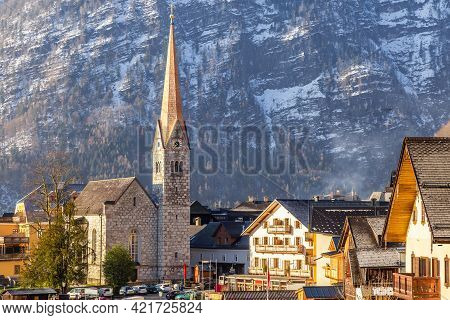 View Of Beautiful Hallstatt Famous Church During Morning Sunrise In Early Spring With Mountain Range