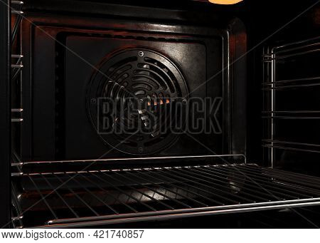 An Upclose View Of The Inside Of An Empty Operational Household Oven With A Glowing Element And Meta