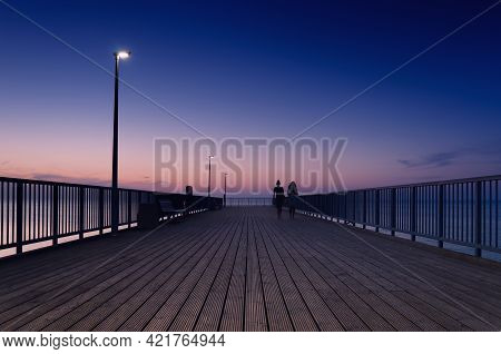Pier On The Sea Coast - Womens Walk At A Quiet Sunset