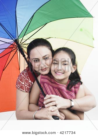 Mother And Daughter With One With Rainbow Umbrella