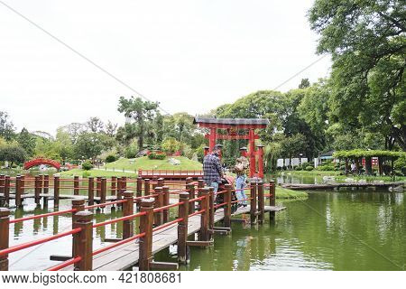 Buenos Aires, Argentina; March 17, 2021: A Young Family Walks Across The Bridge Of Decisions, In The