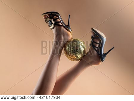 Gold Disco Ball On High Heels. Sexy Legs. Disco Party. Woman Legs With Gold Disco Ball. Celebrate Co