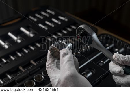 Male Hands In Gloves With Steel Socket Ratchet Handle And Metal Steel Hex Socket. Car And Home Repai