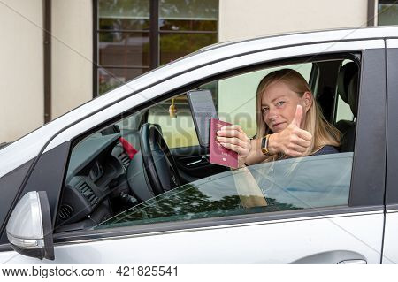 Driver In Car Shows A Digital Covid-19 Immunity Vaccine Passport, New Normal Travel Concept