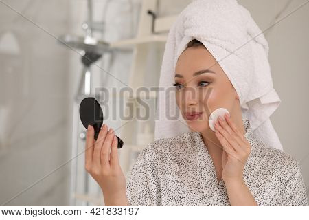 Beautiful Young Woman Applying Face Powder With Puff Applicator In Bathroom At Home