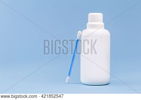 Hydrogen Peroxide, In White Plastic Bottle, With Cotton Swab And Isolated Blue Background, Medicine 