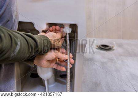 A Bathroom Remodeling Project Installation Of A New White Toilet Bowl. Unfinished Interior Of Repair