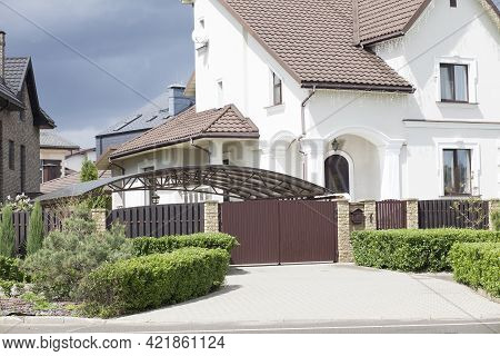 Gateway To A Private Beautiful Well-kept House. The Facade Of A White Plastered Rich Two-story House