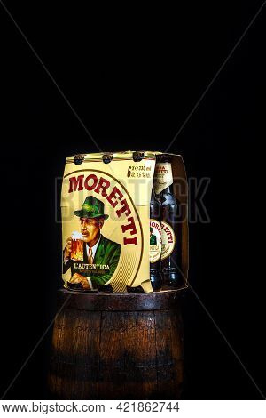 6 Pack Of Birra Moretti Beer On Wooden Barrel With Dark Background. Illustrative Editorial Photo Buc