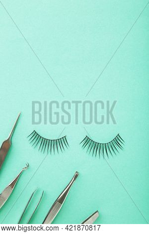 Set Of False Eyelashes Extencions On Mint Background With Tweezers. Minimalism. Top View