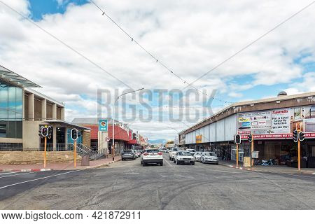 Oudtshoorn, South Africa - April 5, 2021: A Street Scene, With Businesses, People And Vehicles, In O