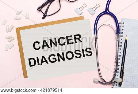 On A Light Pink Background, A Stethoscope, White Pills And Clips For Paper, Glasses In Black Frames 