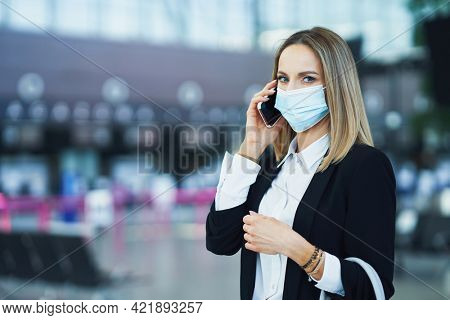 Adult female passenger using smartphone at the airport