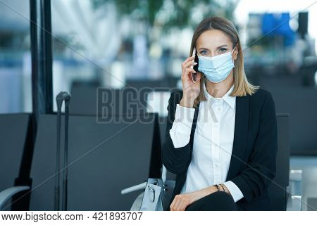 Adult female passenger using smartphone at the airport