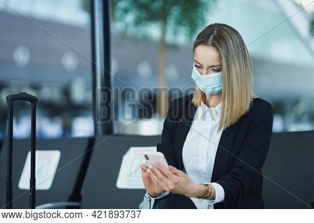 Adult female passenger using smartphone at the airport