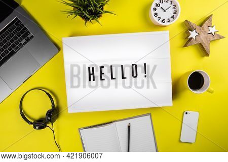 Lightbox With Message Hello On Yellow Background With Laptop, Smartphone, Headphones And Notes. Conc