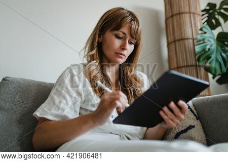 Woman in pyjamas working at home during coronavirus outbreak