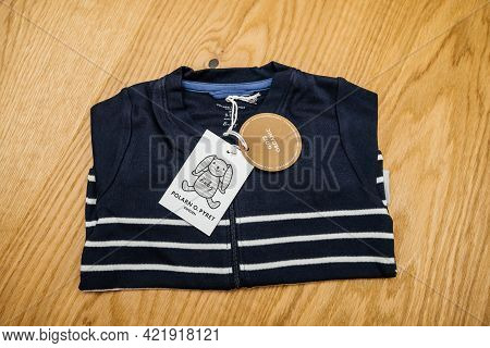 Lyon, France - May 2, 2021: Pov Male Hand Father Holding Infant Baby Clothes Manufactured By The Swe