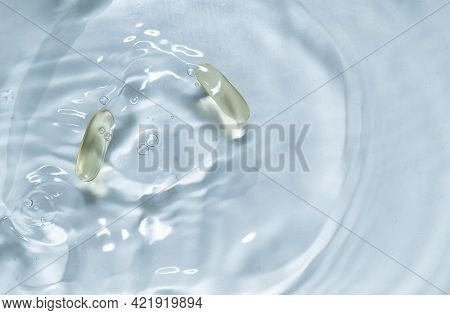 Beauty Skin Care Product. Water Drop Background. Hyaluronic Serum. Vitamin Drop Pill Capsule. Health