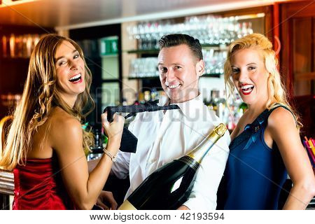 Gode venner - bartender og kvinder - med en stor magnum flaske champagne på bar at have det sjovt, hun pul