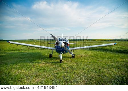 Walking Small Propeller Plane On A Green Field