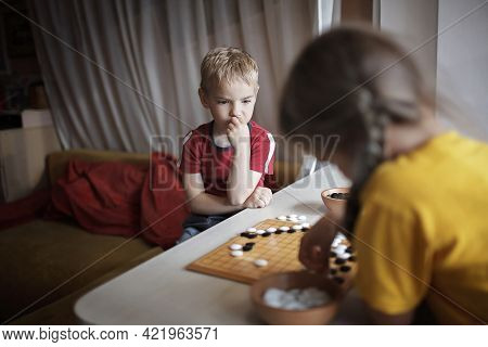 Brother And Sister Playing Chinese Chess Go At Home, Sibling Have Fun Together With Igo Go Stones, W