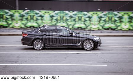 Moscow, Russia - April 2021: Side View Of Bmw 5 Series In Motion. Black Dirty Car Moving On The Stre