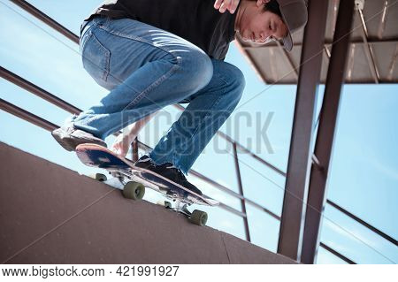 Skateboarder Jumping High On Mini Ramp At Skate Park Outdoor.
