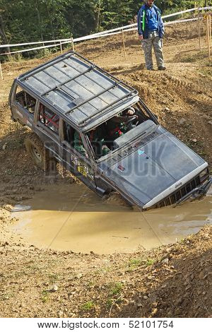 Black Car Is Entering  Into A Puddle Of Mud