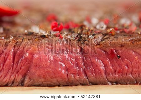 Beef steak on a wooden board and table