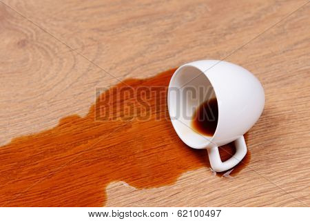 Overturned cup of coffee on floor close-up