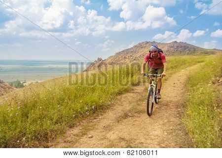 Boys rides a bike in Macin mountains, Tulcea, Romania.