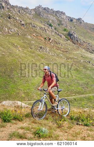 Boys rides a bike in Macin mountains, Tulcea, Romania.