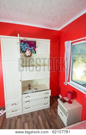 Little girl upside down in open closet at inverted house