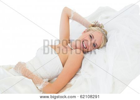 Portrait of happy sensuous bride lying against white background