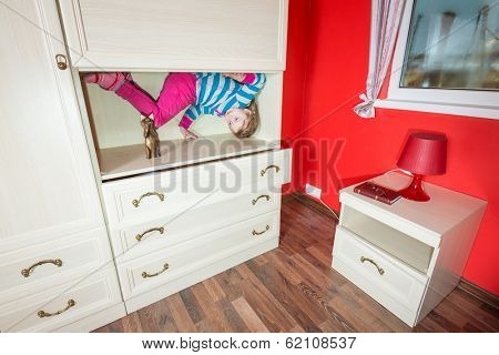 Little girl upside down in the closet at inverted house