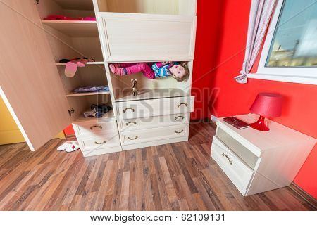 Girl lying upside down in the closet at inverted house