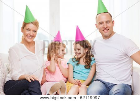 celebration, family, holidays, children and birthday concept - happy family with two chldren in hats celebrating