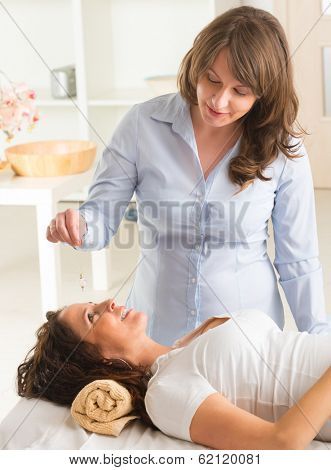 Alternative medicine therapist using pendulum to make a diagnosis