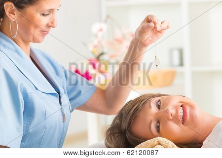 Alternative medicine therapist using pendulum to make a diagnosis