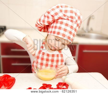 Little Girl With Chef Hat Stirrring Cookie Dough