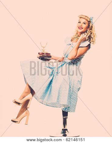Coquette blond pin up style young woman in blue dress with vintage phone 