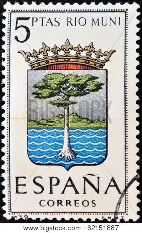 A stamp printed in Spain dedicated to Arms of Provincial Capitals shows Rio Muni