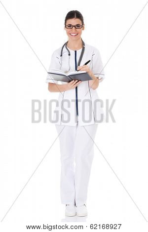 Young female doctor wirting in a book. Isolated on white. 