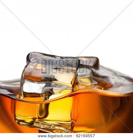 Close up splash of whiskey with ice isolated on white