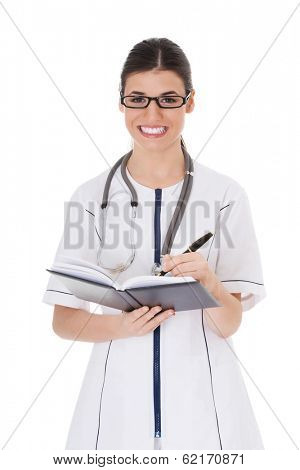 Young female doctor wirting in a book. Isolated on white. 