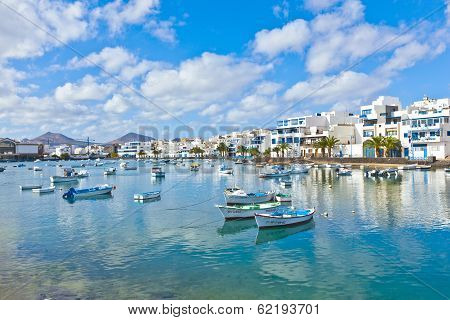 ARRECIFE - SPAIN DEC 23: fisherman anchors the boat in Charco de San Gines on DEC 232010 in Arrecife Spain. The harbor area was remodelled by Canarian architect César Manrique in 1984.