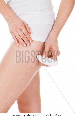 Woman Applying Microdermabrasion On Thigh