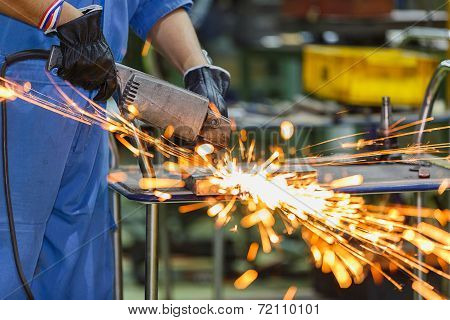 Worker Grinding Steel By Electric Grinding Machine